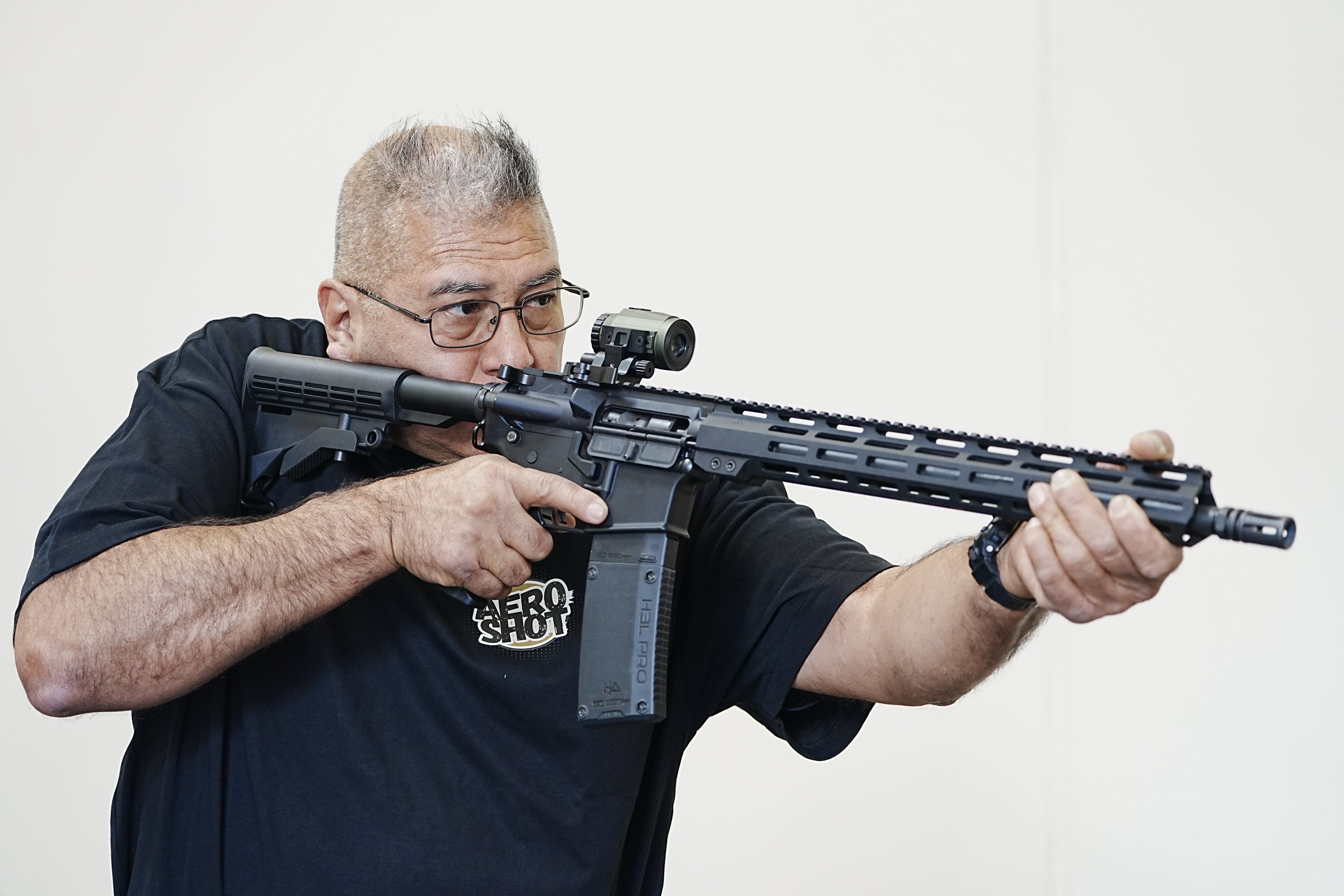 man aiming shotgun with tactical weapon light attached for shooting training